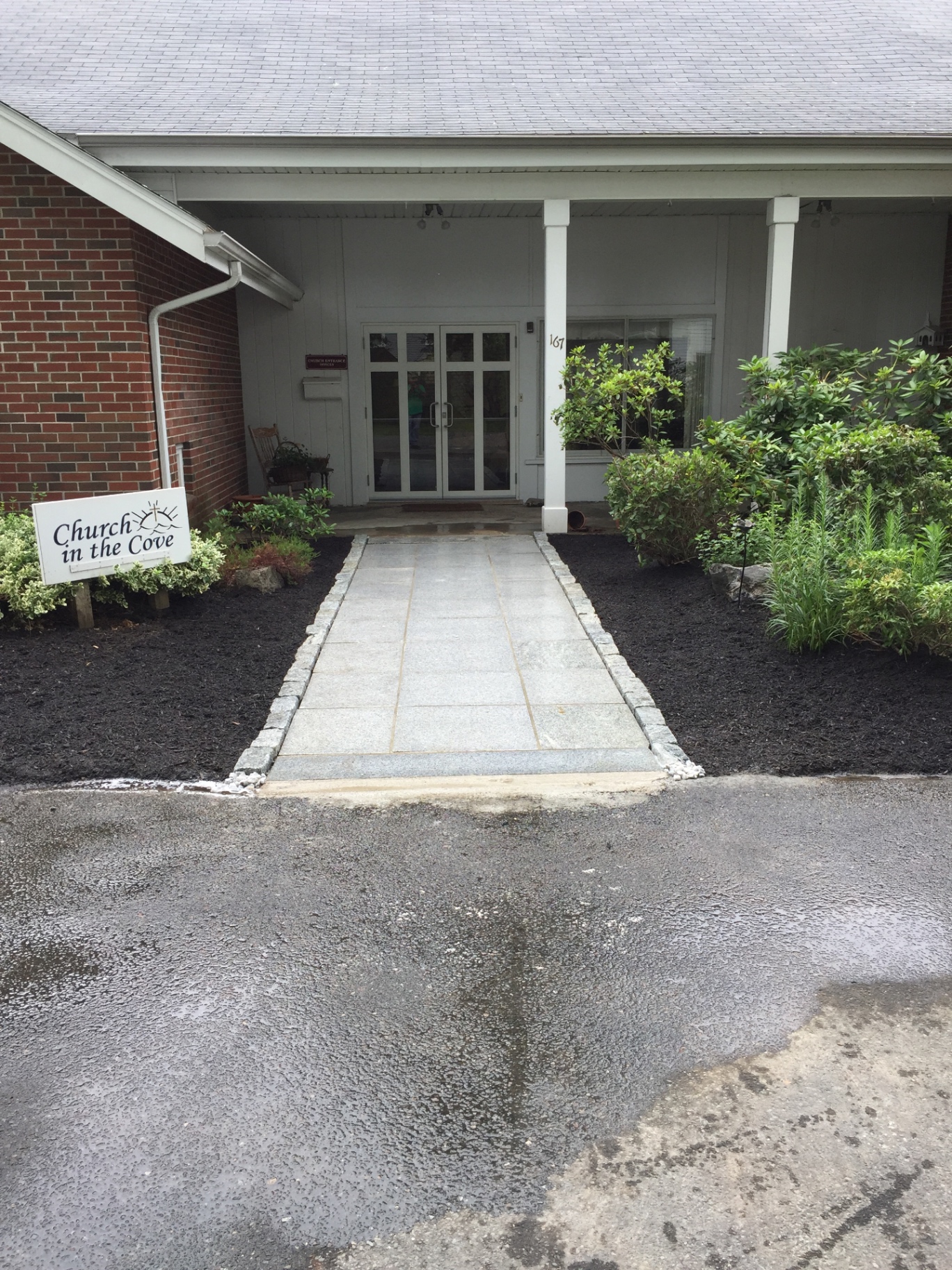 Granite slab walkway with cobblestone edging leading to church entry
