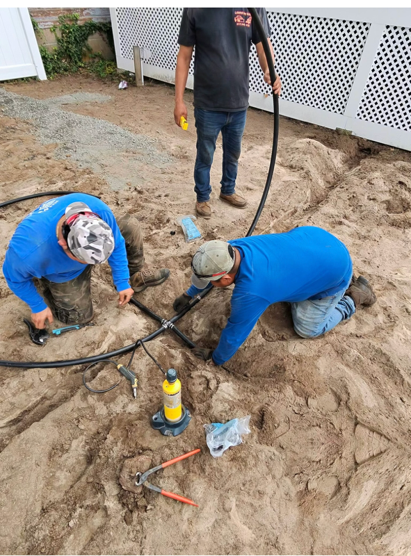 Landscapers installing an irrigation line in a backyard