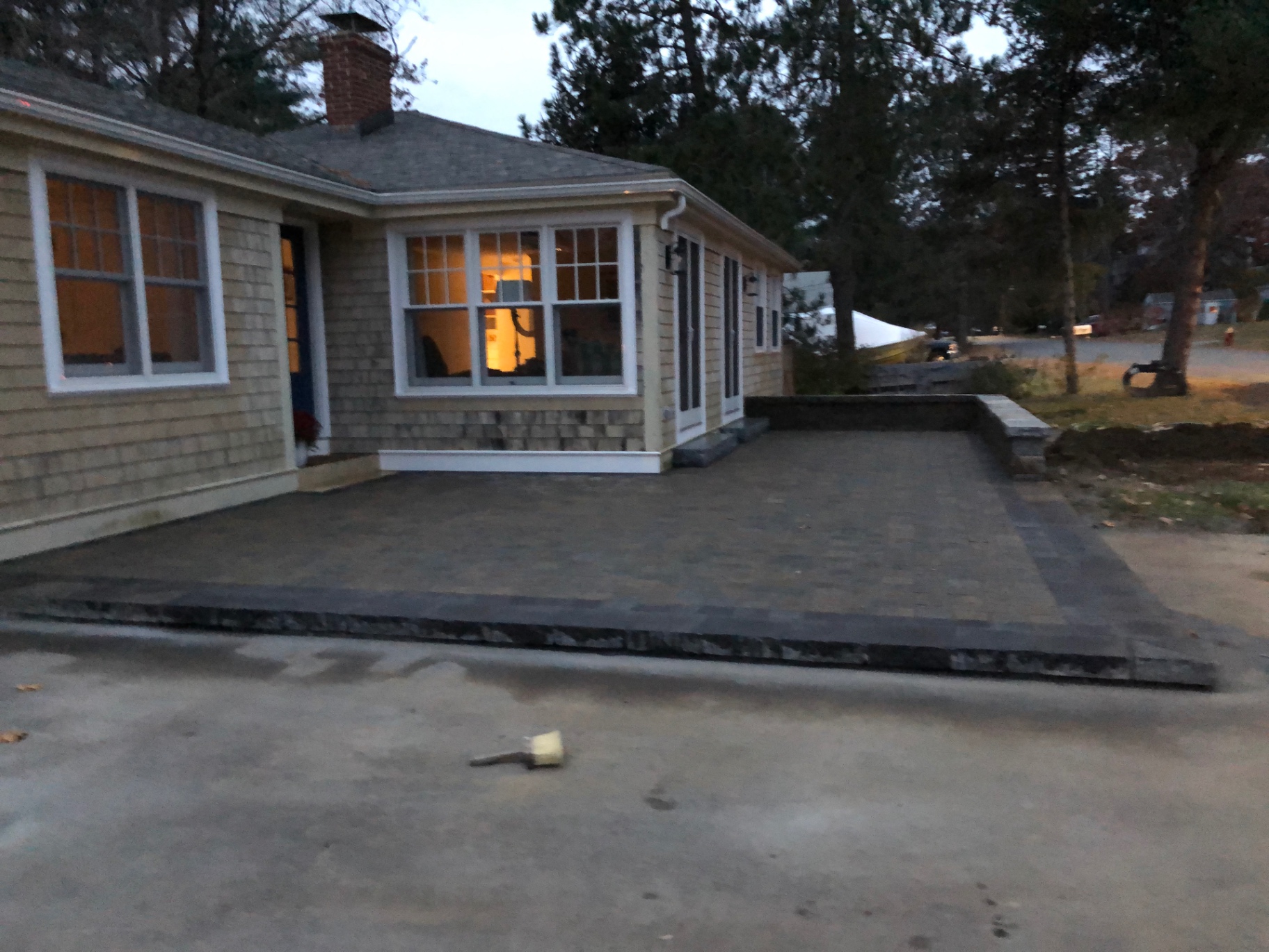 Large charcoal paver patio with contrasting border along a home