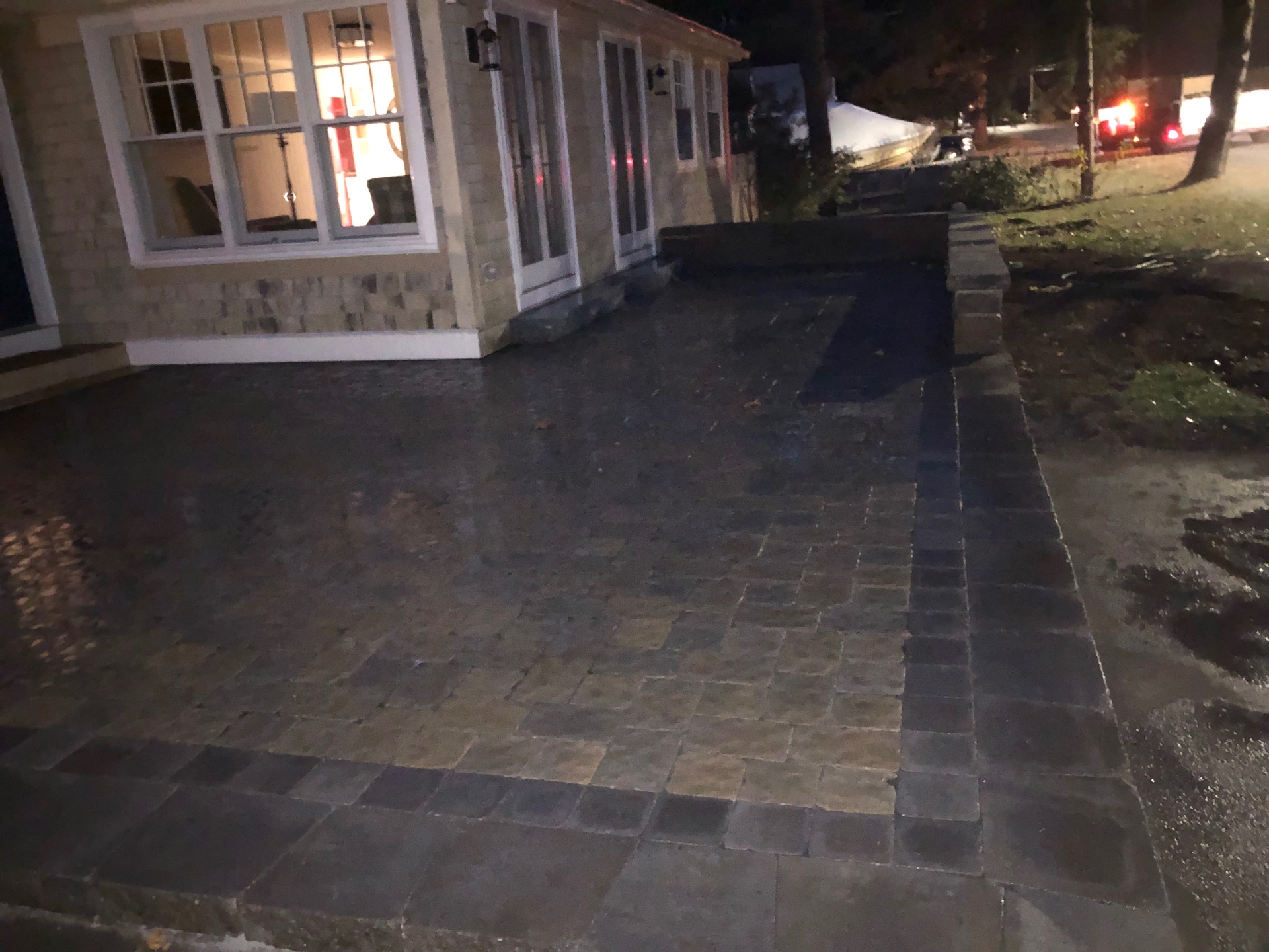 Paver driveway apron and walkway with soldier-course border at dusk