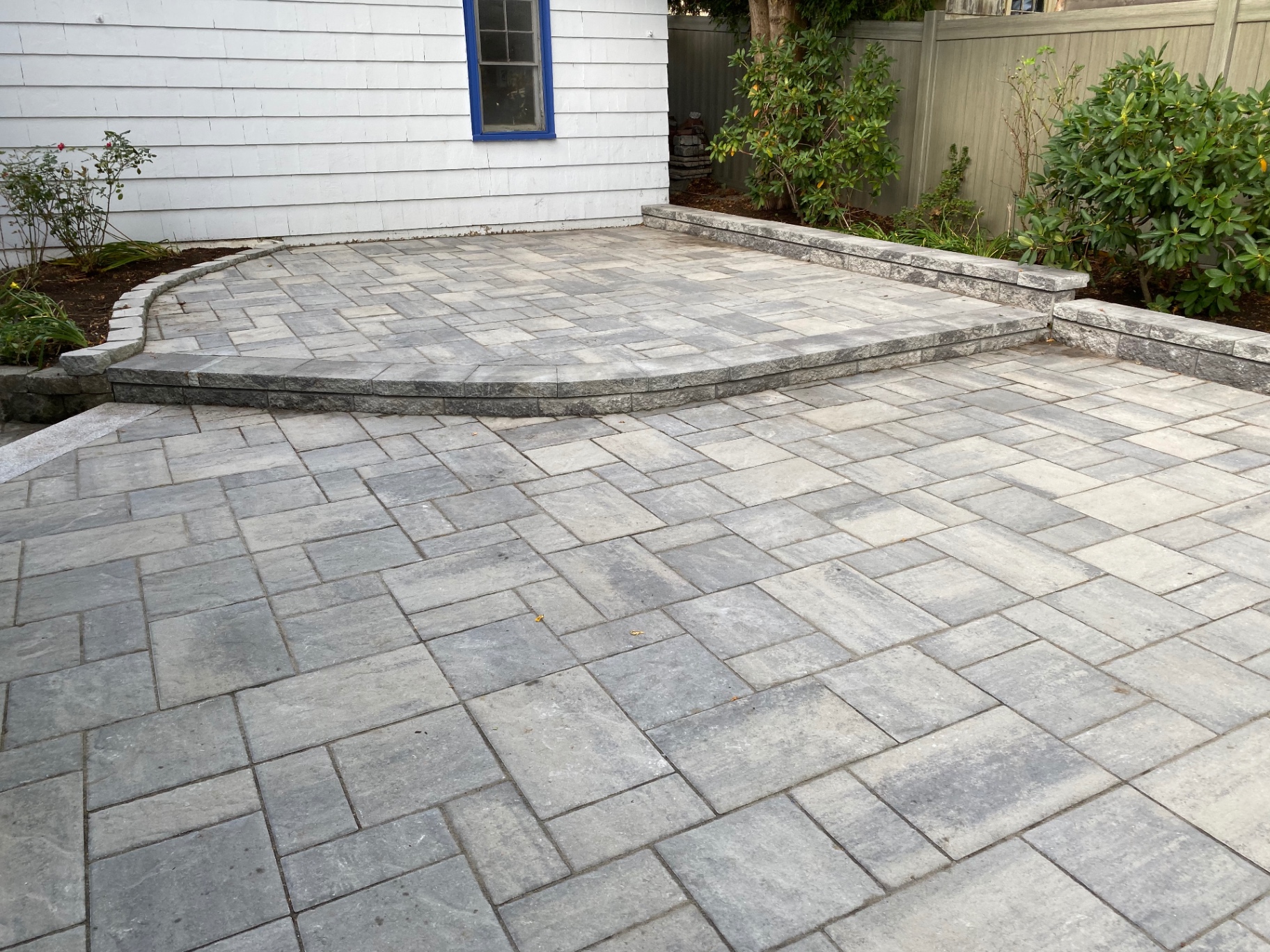 Curved bluestone paver patio with granite retaining wall